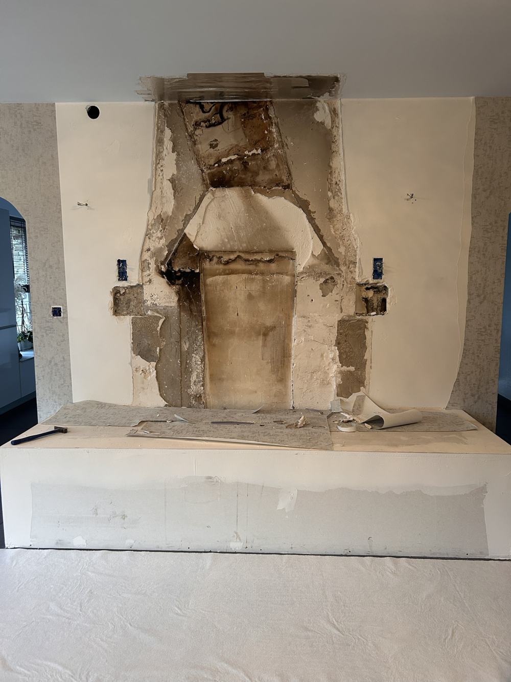 Mur de cheminée avant travaux : enduit abîmé