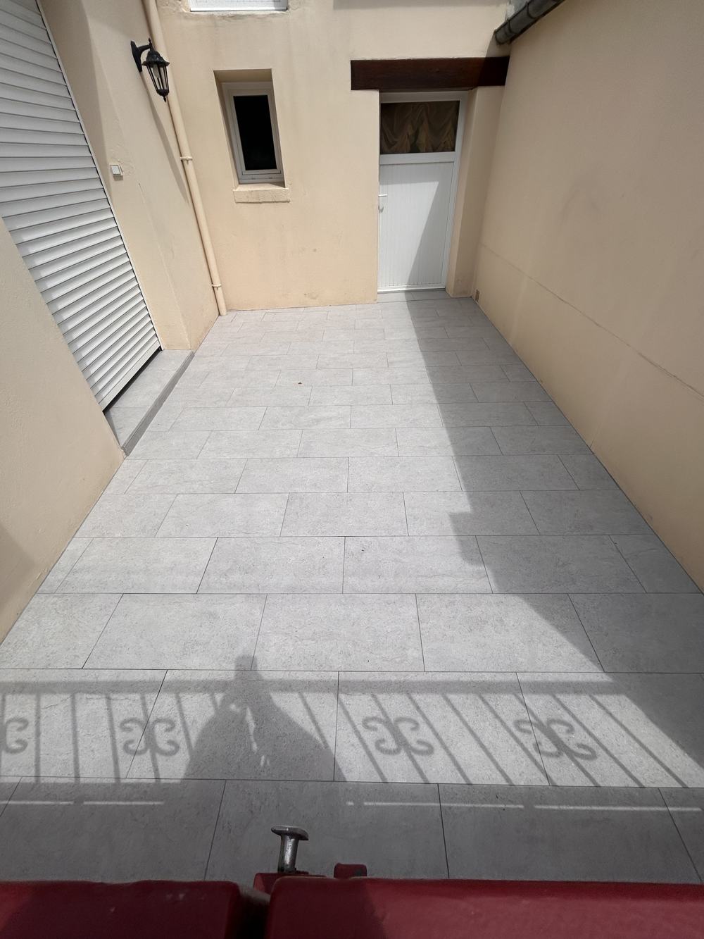 Cour après travaux : grandes dalles de carrelage gris clair