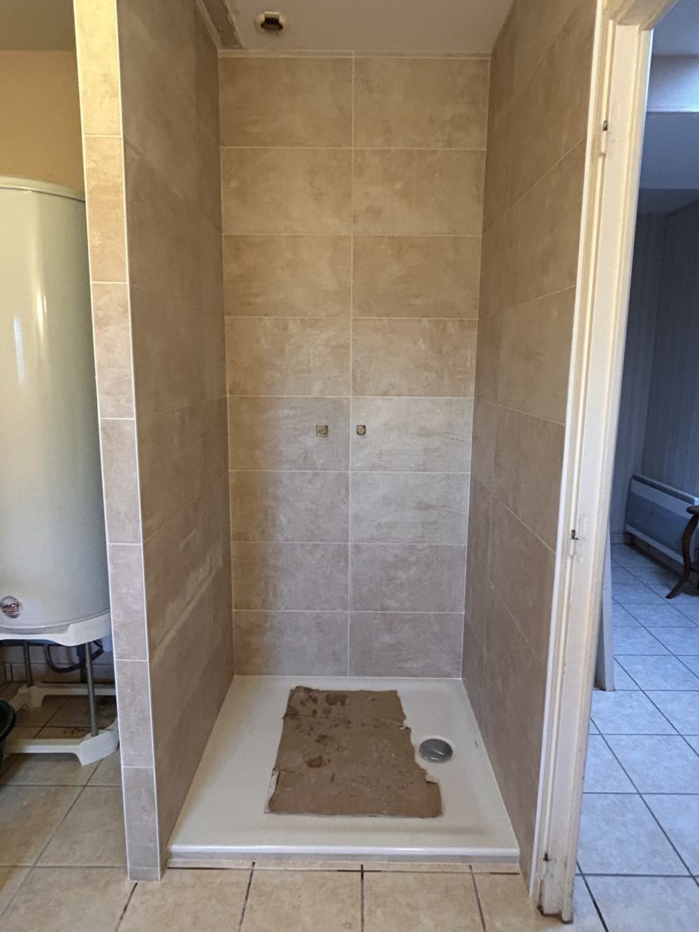 Douche terminée : grands carreaux beiges et receveur blanc