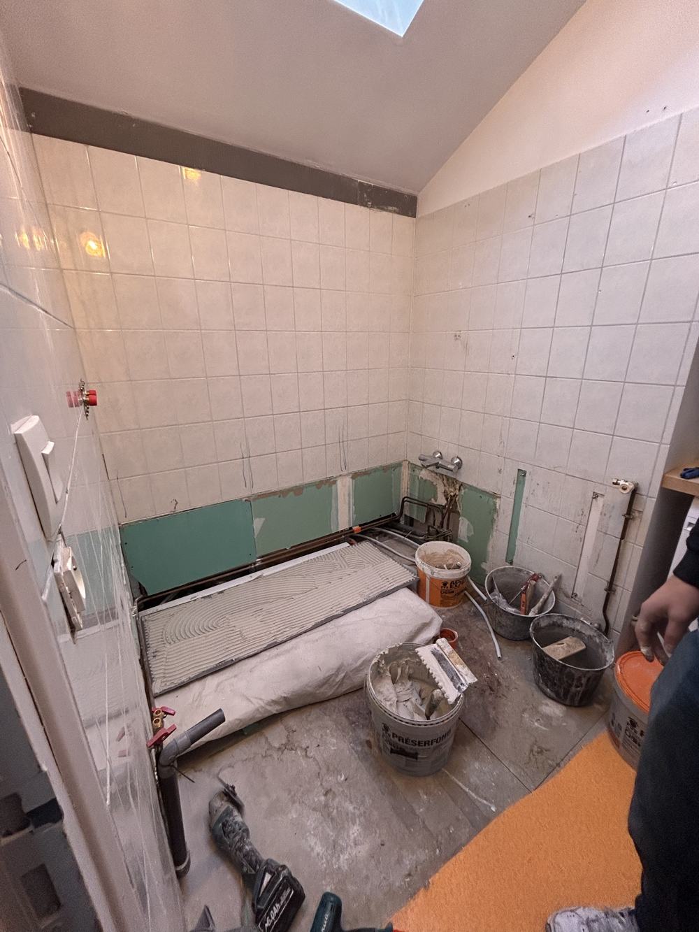 Salle de bain avant travaux : ancienne faïence blanche en cours de dépose