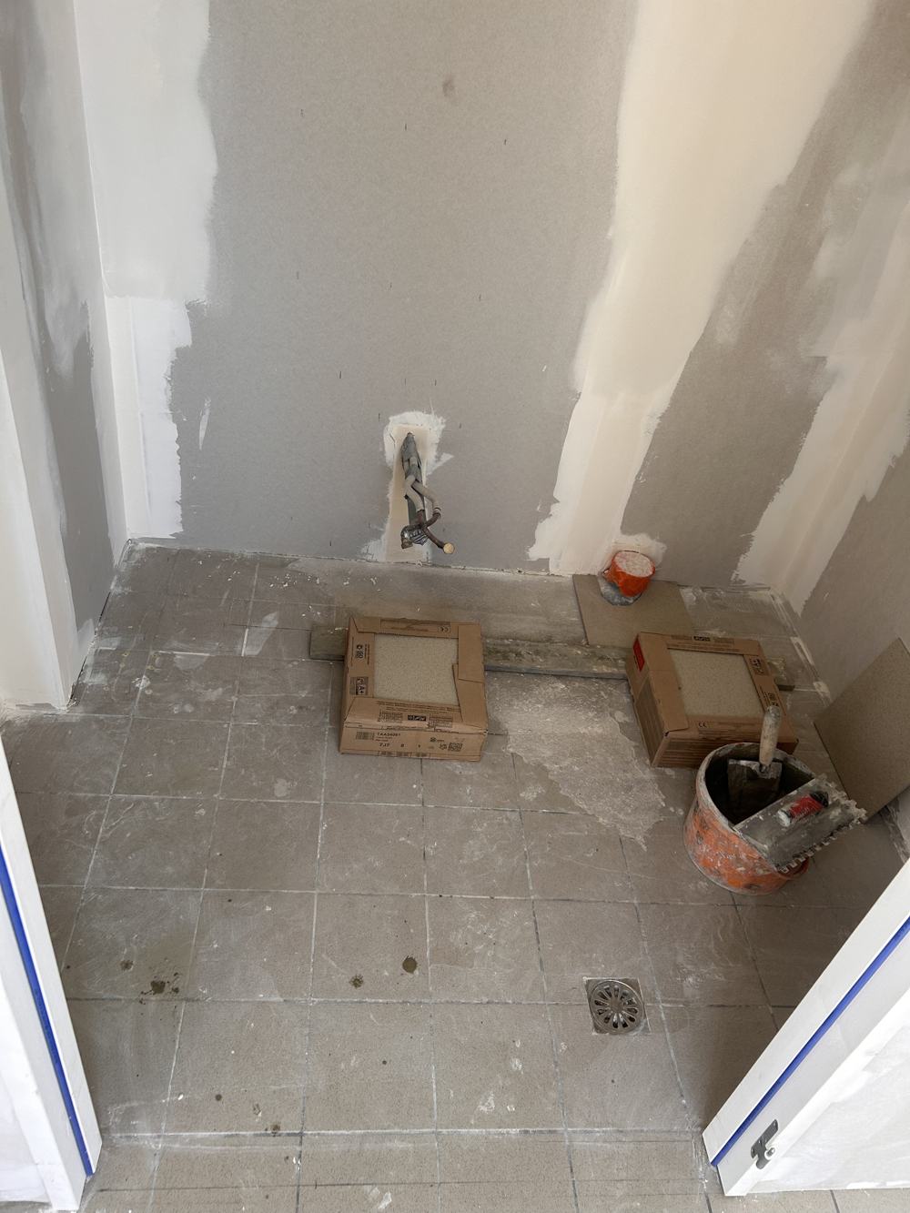 WC avant travaux : sol gris brut et murs en plaque de plâtre